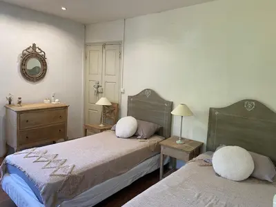 a bedroom with two beds and a dresser and a mirror at BandB les rosiers - chambre Eglantine in Conca