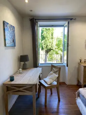 a room with a wooden table and a window at BandB les rosiers - chambre Eglantine in Conca