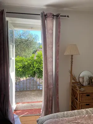 a bedroom with a sliding glass door to a patio at BandB les rosiers - chambre Garance in Conca
