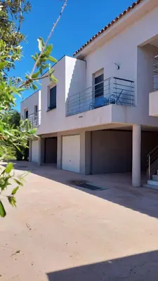 a large white house with a parking lot at Casa di Lume - Superbe T3 4 étoiles à Bonifacio in Bonifacio