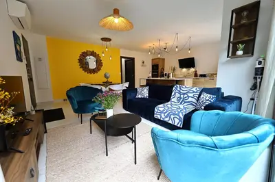 a living room with a blue couch and a table at Casa di Lume - Superbe T3 4 étoiles à Bonifacio in Bonifacio