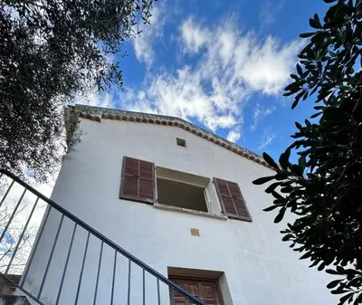 a white building with a window on the side of it at Au coeur du village de Calenzana in Calenzana