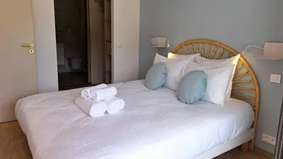 a white bed with towels and pillows on it at Le Berceau d'Asciaghju Palombaggia - Accès plage et Piscine privée in Porto-Vecchio