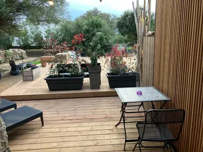 a patio with a table and chairs and potted plants at Villa vue mer, jardin terrasse, parking privé à 300m du centre-ville de Porto-Vecchio in Porto-Vecchio