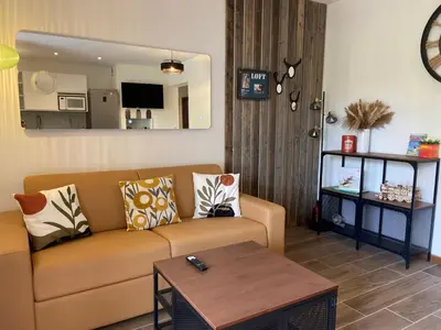 a living room with a couch and a table at Villa vue mer, jardin terrasse, parking privé à 300m du centre-ville de Porto-Vecchio in Porto-Vecchio