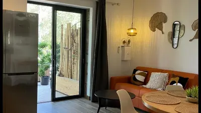 a living room with a couch and a table at Villa vue mer, jardin terrasse, parking privé à 300m du centre-ville de Porto-Vecchio in Porto-Vecchio