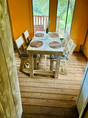 a wooden table and chairs on a wooden deck at Lodge A NASSA in Olivese