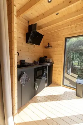 a kitchen in a log cabin with a large window at chalet Arena in Porto-Vecchio