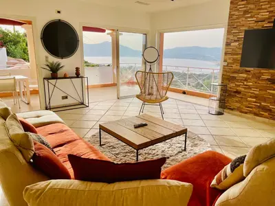 a living room with a couch and a table at Villa Sì- Villa indépendante 3 chambres avec piscine et magnifique vue mer en plein centre de Porticcio in Porticcio