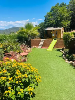 a backyard with a playground with a slide and flowers at Villa Sì- Villa indépendante 3 chambres avec piscine et magnifique vue mer en plein centre de Porticcio in Porticcio