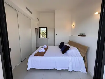 a bedroom with a bed with white sheets and pillows at Bergerie Piana d'architecte neuve, 8 pers, piscine chauffée, à 10 min plage in Gialla