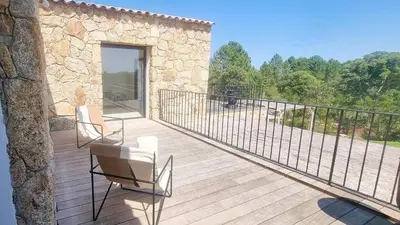 a wooden deck with two chairs and a fence at Bergerie Piana d'architecte neuve, 8 pers, piscine chauffée, à 10 min plage in Gialla