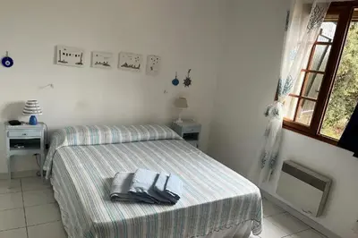 a bedroom with a bed and a window at Villa pieds dans l'eau sur la plage in Pianottoli-Caldarello