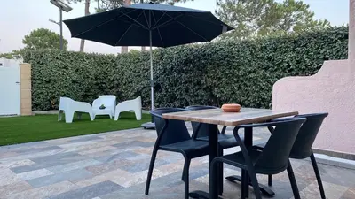 a table with chairs and an umbrella on a patio at A casa di Leia in Borgo