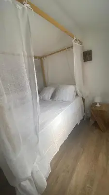 a white bed with a canopy in a room at A casa di Leia in Borgo