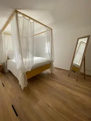 a bed with a canopy in a room with a mirror at A casa di Leia in Borgo