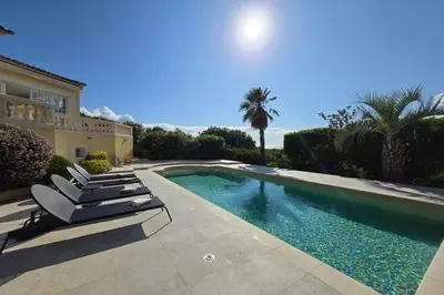 a swimming pool with lounge chairs next to a house at Villa de Prestige - clim - vue mer panoramique - 8 pers - 4 chambres in Pietrosella