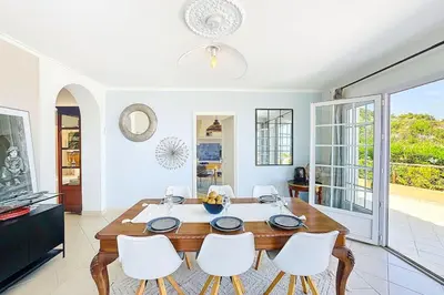 a dining room with a table and white chairs at Villa de Prestige - clim - vue mer panoramique - 8 pers - 4 chambres in Pietrosella