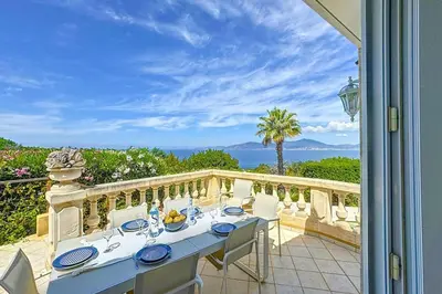 a table on a balcony with a view of the ocean at Villa de Prestige - clim - vue mer panoramique - 8 pers - 4 chambres in Pietrosella