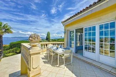 a house with a table and chairs on a patio at Villa de Prestige - clim - vue mer panoramique - 8 pers - 4 chambres in Pietrosella