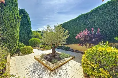 a garden with a tree in a courtyard with bushes at Villa de Prestige - clim - vue mer panoramique - 8 pers - 4 chambres in Pietrosella