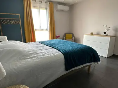 a bedroom with a bed with a blue blanket on it at 5 min des plages - Appt 2 chambres A Casa Bella in Lucciana
