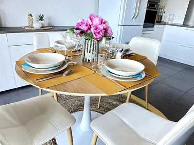 a table with plates and flowers on it in a kitchen at 5 min des plages - Appt 2 chambres A Casa Bella in Lucciana