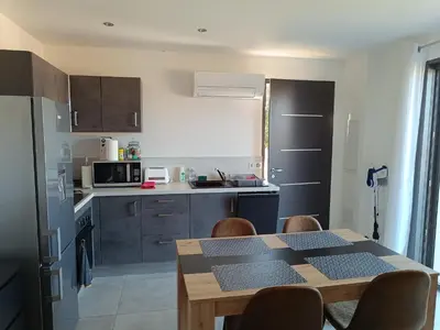 a kitchen with a table and chairs and a table and a kitchen at Doume et Coco T1 30M2 Vue mer in Taglio-Isolaccio