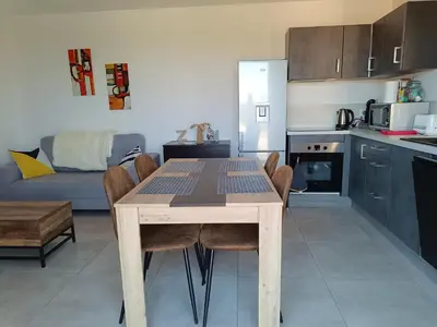 a kitchen with a wooden table and chairs in a room at Doume et Coco T1 30M2 Vue mer in Taglio-Isolaccio