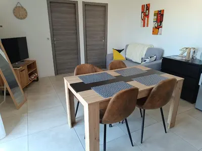 a dining room table and chairs in a living room at Doume et Coco T1 30M2 Vue mer in Taglio-Isolaccio