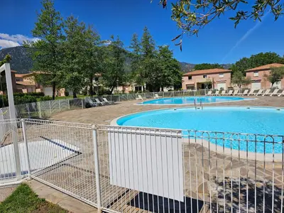a swimming pool with a fence around it at Villa 7 personnes résidence Mélody in Santa-Maria-Poggio