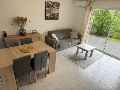 a living room with a table and a couch at Villa 7 personnes résidence Mélody in Santa-Maria-Poggio