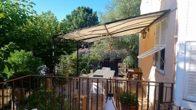 a patio with a canopy on a house at BandB les rosiers - Hellébore in Conca