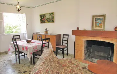 a living room with a table and a fireplace at Holiday Home Sagone Xlvii in Sagone