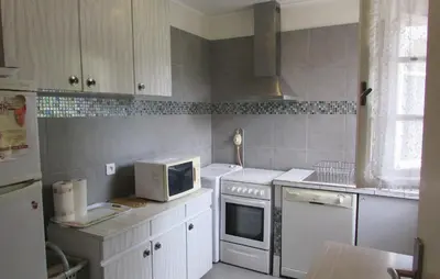 a kitchen with white appliances and a computer on the counter at Holiday Home Sagone Xlvii in Sagone