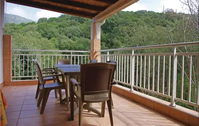 a porch with a table and chairs on a balcony at Holiday Home Sagone Xlvii in Sagone