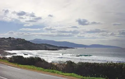 a road next to a beach with the ocean at Nice Apartment In Sagone With Kitchen in Sagone