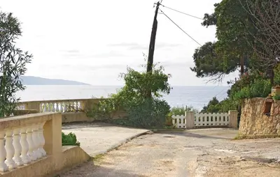 a white fence with the ocean in the background at Nice Apartment In Sagone With Kitchen in Sagone