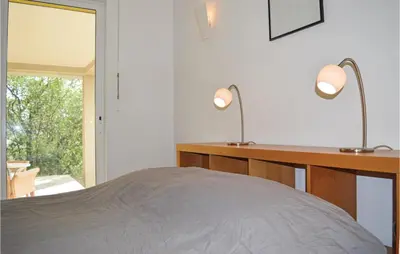 a bedroom with two lamps on a desk and a bed at Cozy Home In San Giuliano With Wifi in San-Giuliano