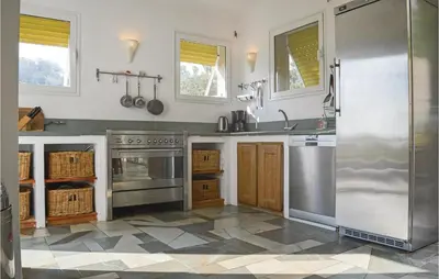 a kitchen with stainless steel appliances and a tile floor at Cozy Home In San Giuliano With Wifi in San-Giuliano