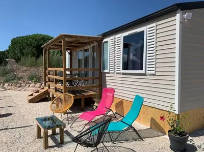 a group of chairs sitting outside of a tiny house at Mobil- home à Calenzana in Calenzana