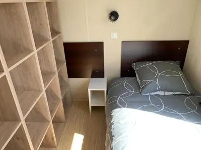 a bedroom with a bed and a wooden wall at Mobil- home à Calenzana in Calenzana