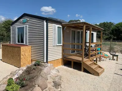 a small cabin with a porch and a deck at Mobil- home à Calenzana in Calenzana