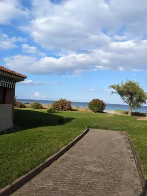 a walkway leading to a field with the ocean in the background at Vue sur mer cala Di sognu in San-Nicolao