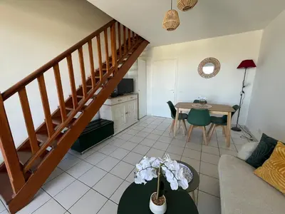 a living room with a staircase and a table at Duplex vue mer à Piana Verde Canale-di-verde in Canale-di-Verde