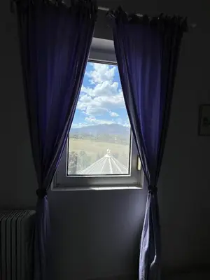 a window with a blue curtain in a room at Duplex vue mer à Piana Verde Canale-di-verde in Canale-di-Verde