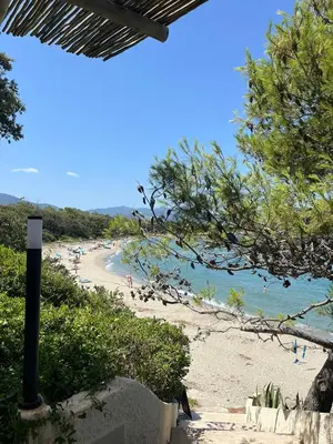 a beach with a bunch of people in the water at Duplex vue mer à Piana Verde Canale-di-verde in Canale-di-Verde
