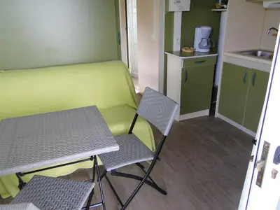 a small kitchen with a table and two chairs at Petit chalet in Pianottoli-Caldarello