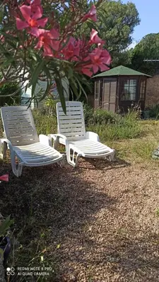 two white lounge chairs sitting in the grass at Petit chalet in Pianottoli-Caldarello