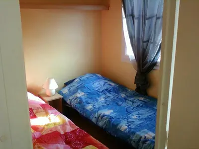 a small bedroom with a bed and a window at Petit chalet in Pianottoli-Caldarello